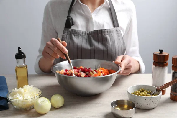 stock image Woman preparing tasty vinaigrette salad at light wooden table, closeup