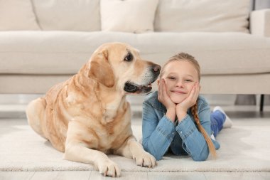 Evde yerde Labrador Retriever 'ı olan sevimli bir çocuk. Sevimli hayvan.