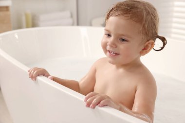 Tatlı küçük kız evde banyo yapıyor.