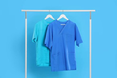 Tıbbi üniformalar açık mavi arkaplanda.