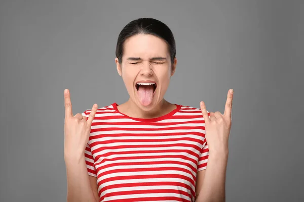 Happy Young Woman Showing Her Tongue Making Rock Gesture Grey — Stock Photo, Image