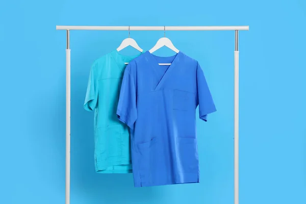 Uniformi Mediche Rack Contro Sfondo Azzurro — Foto Stock