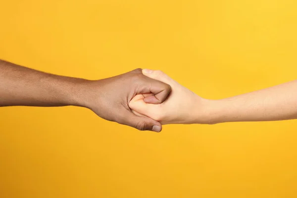 International Relationships People Strongly Joining Hands Orange Background Closeup — Stock Photo, Image