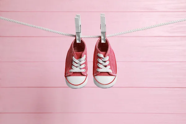 Cute Baby Sneakers Drying Washing Line Pink Wooden Wall — Stock Photo, Image