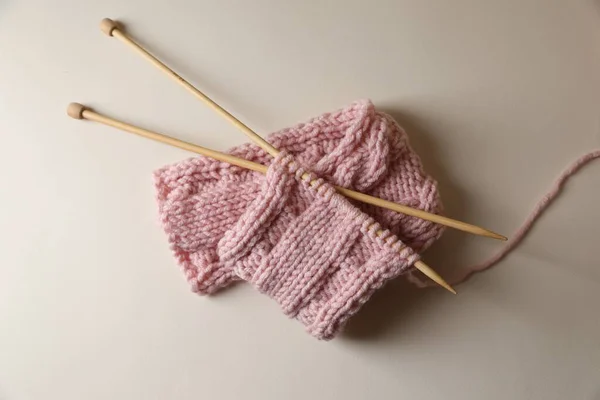 ピンクの編みとベージュの背景の針 トップビュー — ストック写真