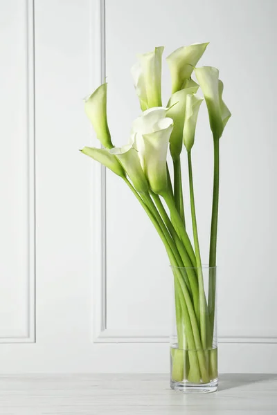 stock image Beautiful calla lily flowers in vase on white table