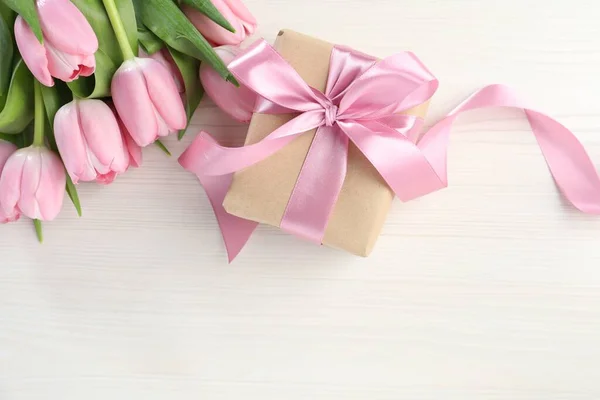 漂亮的礼品盒 白色木制背景上有蝴蝶花和粉色郁金香花 案文的篇幅 — 图库照片