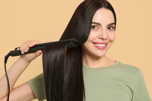 Beautiful Happy Woman Using Hair Iron Beige Background — Stock Photo, Image