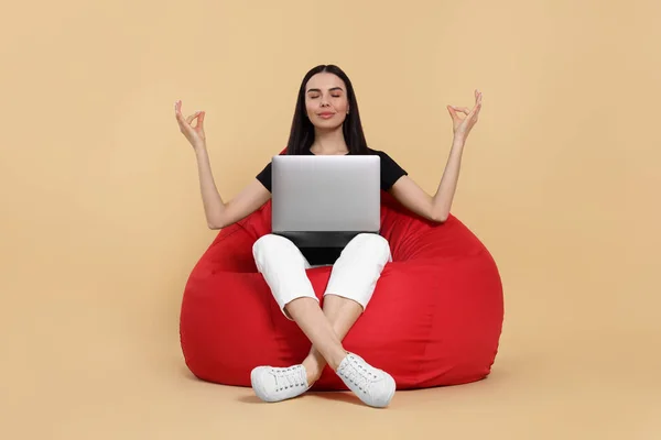 Schöne Frau Mit Laptop Sitzt Auf Sitzsack Stuhl Und Meditiert — Stockfoto