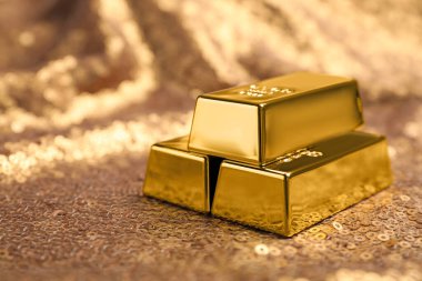 Bronz pullu kumaş üzerine parlak altın külçeler, yakın plan. Metin için boşluk