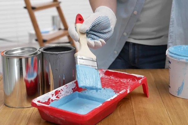 Mann Nimmt Hellblaue Farbe Mit Pinsel Aus Tablett Holztisch Haus — Stockfoto