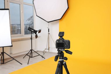 Modern fotoğraf stüdyosunda tripod ve profesyonel ışıklandırma ekipmanları var.