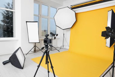 Modern fotoğraf stüdyosunda tripod ve profesyonel ışıklandırma ekipmanları var.