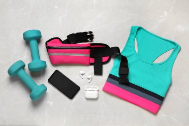 Açık gri masada pembe bel çantalı düz kompozisyon.