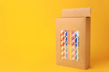 Turuncu arka planda bir sürü kağıt kamış içilen bir kutu. Metin için boşluk