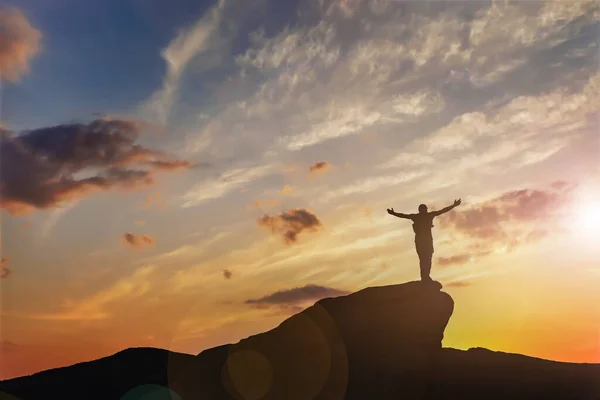 Stock image Silhouette of man on peak at sunset. Space for text