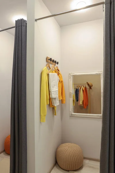 Dressing room with mirror in fashion store. Stylish design