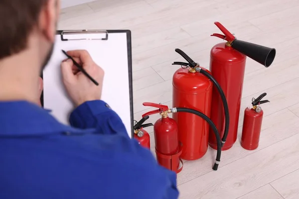 Hombre Con Portapapeles Comprobando Extintores Interiores Primer Plano — Foto de Stock