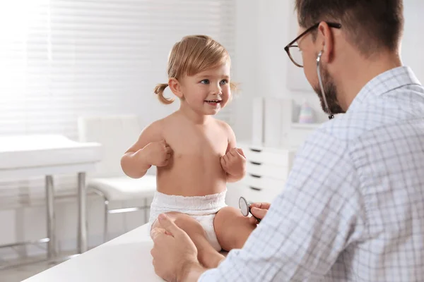 小児科医は診療所で聴診器で赤ちゃんを調べる — ストック写真