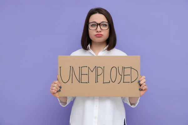 紫の背景に未就職と書かれた看板を持つ若い女性 — ストック写真