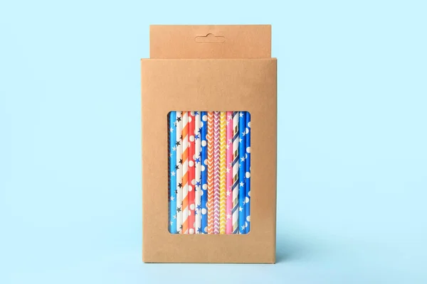 stock image Box with many paper drinking straws on light blue background