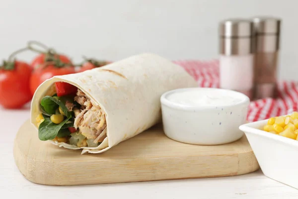 stock image Delicious tortilla wrap with tuna and sauce on white wooden table