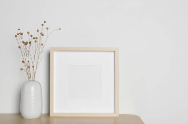 Boş fotoğraf çerçevesi ve vazo ve ahşap masanın üzerinde kurumuş dekoratif çiçekler. Tasarım için model