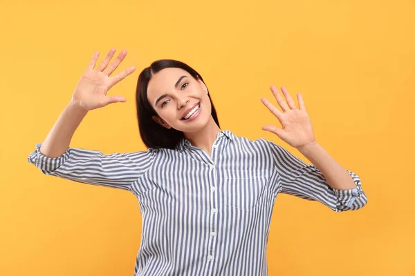 Ευτυχισμένη Γυναίκα Δίνει Κόλλα Πέντε Και Δύο Χέρια Πορτοκαλί Φόντο — Φωτογραφία Αρχείου