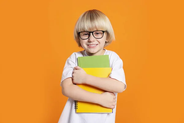 Söt Liten Pojke Bär Glasögon Med Böcker Orange Bakgrund — Stockfoto