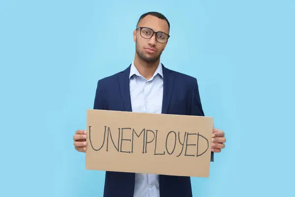 Giovane Uomo Possesso Segno Con Parola Disoccupato Sfondo Azzurro — Foto Stock