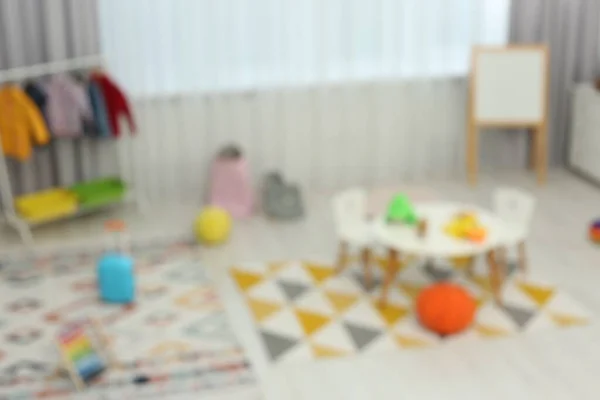 異なるおもちゃや家具と子供の遊び場のぼやけた景色 スタイリッシュな幼稚園のインテリア — ストック写真