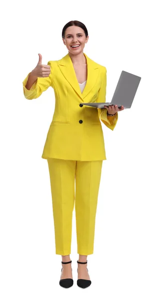 美しいですビジネスマン女性で黄色スーツとともにラップトップ表示親指アップ上の白い背景 — ストック写真