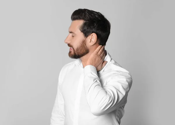 軽い背景で首の痛みに苦しむ男 関節炎の症状 — ストック写真
