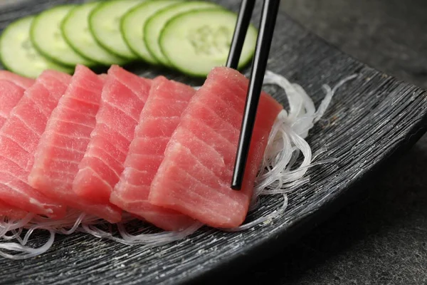 Biorąc Smaczne Sashimi Kawałek Świeżego Surowego Tuńczyka Makaronem Szklanym Talerza — Zdjęcie stockowe