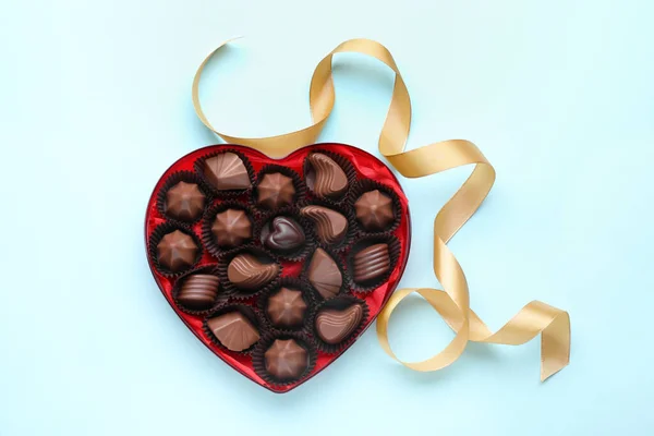心形盒子 有美味的巧克力糖果和浅蓝色背景的缎带 — 图库照片