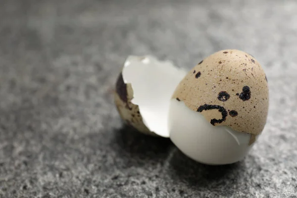 stock image Boiled quail egg partly in shell on grey table, closeup. Space for text