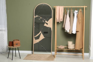 Kırık ayna ve içinde zeytin duvarları olan ahşap askı.