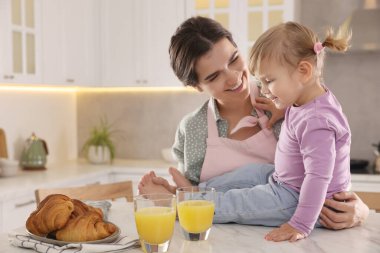 Anne ve küçük kızı mutfakta kahvaltı ediyorlar.