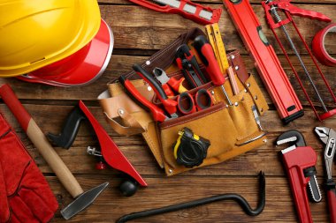 Deri kemer ve ahşap masada tamir için farklı aletler.