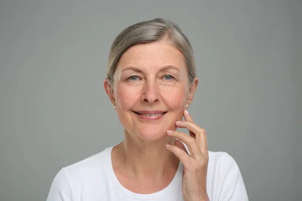 灰色の背景に老化肌のシニア女性の肖像画 更生保護 — ストック写真