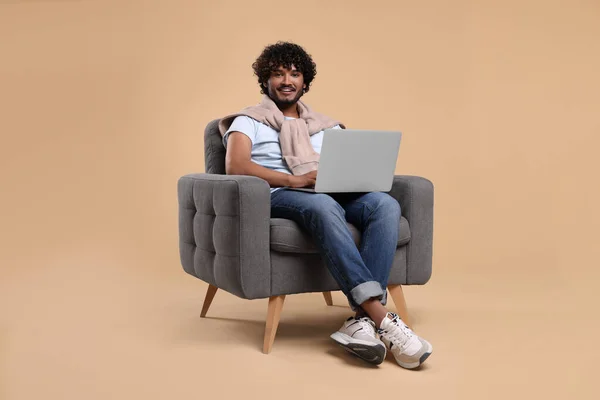 Sorrindo Homem Com Laptop Sentado Poltrona Fundo Bege — Fotografia de Stock