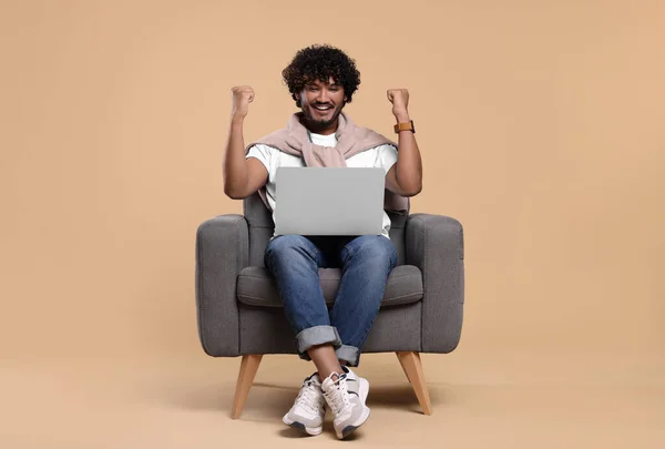 Homem Feliz Com Laptop Sentado Poltrona Fundo Bege — Fotografia de Stock