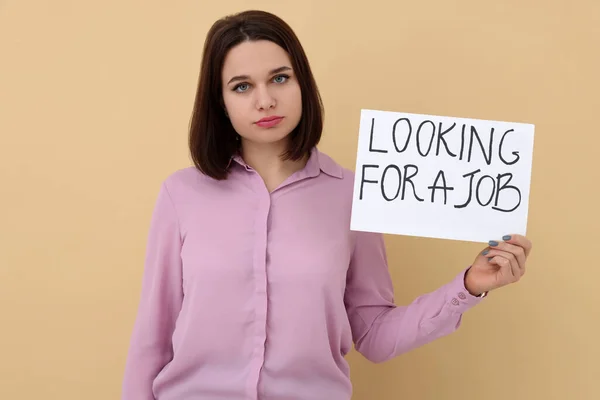 Young Unemployed Woman Holding Sign Phrase Looking Job Beige Background — Stock Photo, Image