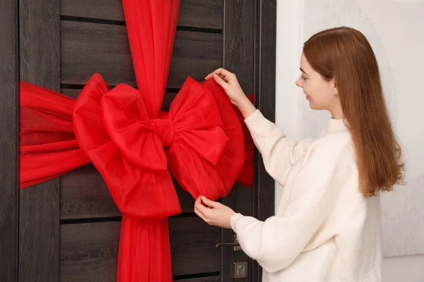 室内用红色弓装饰木门的女人 圣诞气氛 — 图库照片