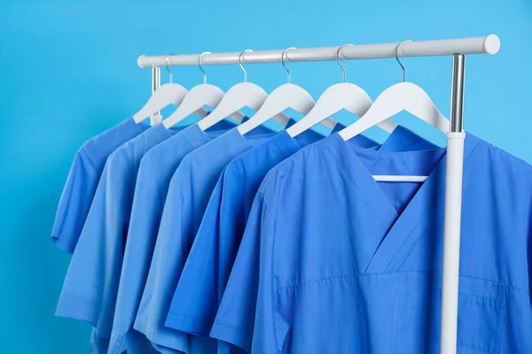 ライトブルーの背景を背景にラック上の医療用制服 — ストック写真