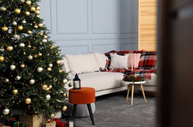 Beautiful Christmas tree, gift boxes and sofa in living room