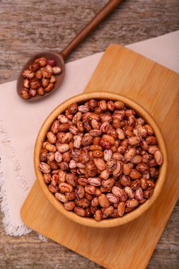 Kuru fasulyeli kase ve kaşık eski ahşap masada, düz yatıyordu.