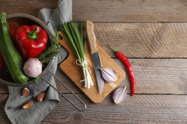 Ratatouille pişiriyorum. Sebzeler, biberiye ve bıçak ahşap masada, düz yatıyordu.