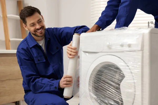 Male Movers Stretch Film Wrapping Washing Machine Bathroom New House — Stockfoto