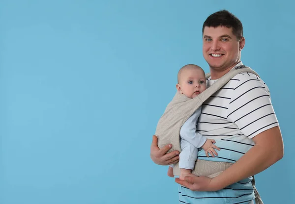 Padre Che Tiene Bambino Fionda Marsupio Sfondo Azzurro Spazio Testo — Foto Stock